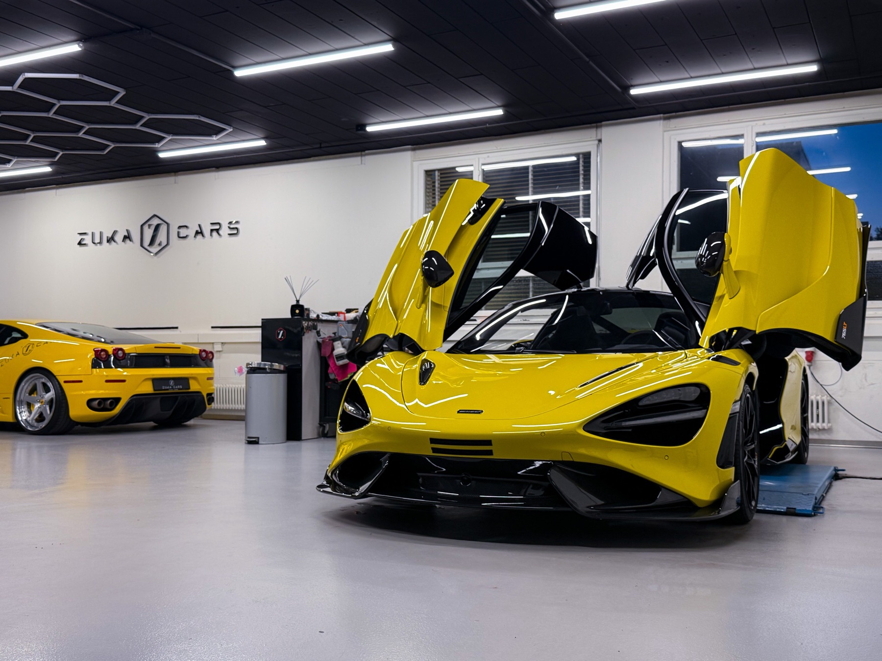 Gelber McLaren mit geöffneten Flügeltüren in der Werkstatt